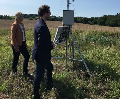 Minister Jan Philipp Albrecht steht vor einer Wetterstation des EIP-Projekts OnFarm Wetter.