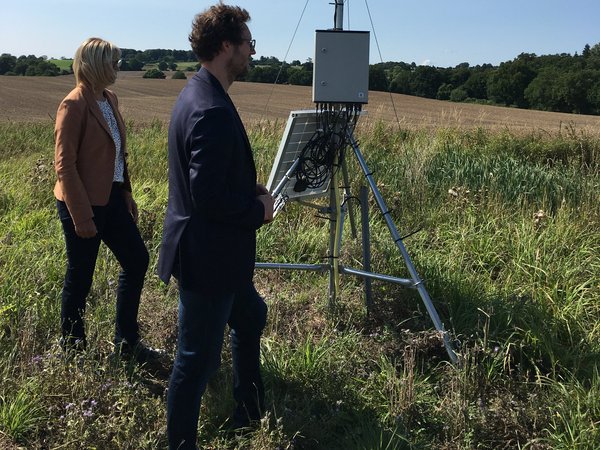 Minister Jan Philipp Albrecht steht vor einer Wetterstation des EIP-Projekts OnFarm Wetter.