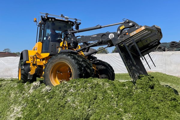 Die Grassilage wird mit einer Maschine verdichtet.